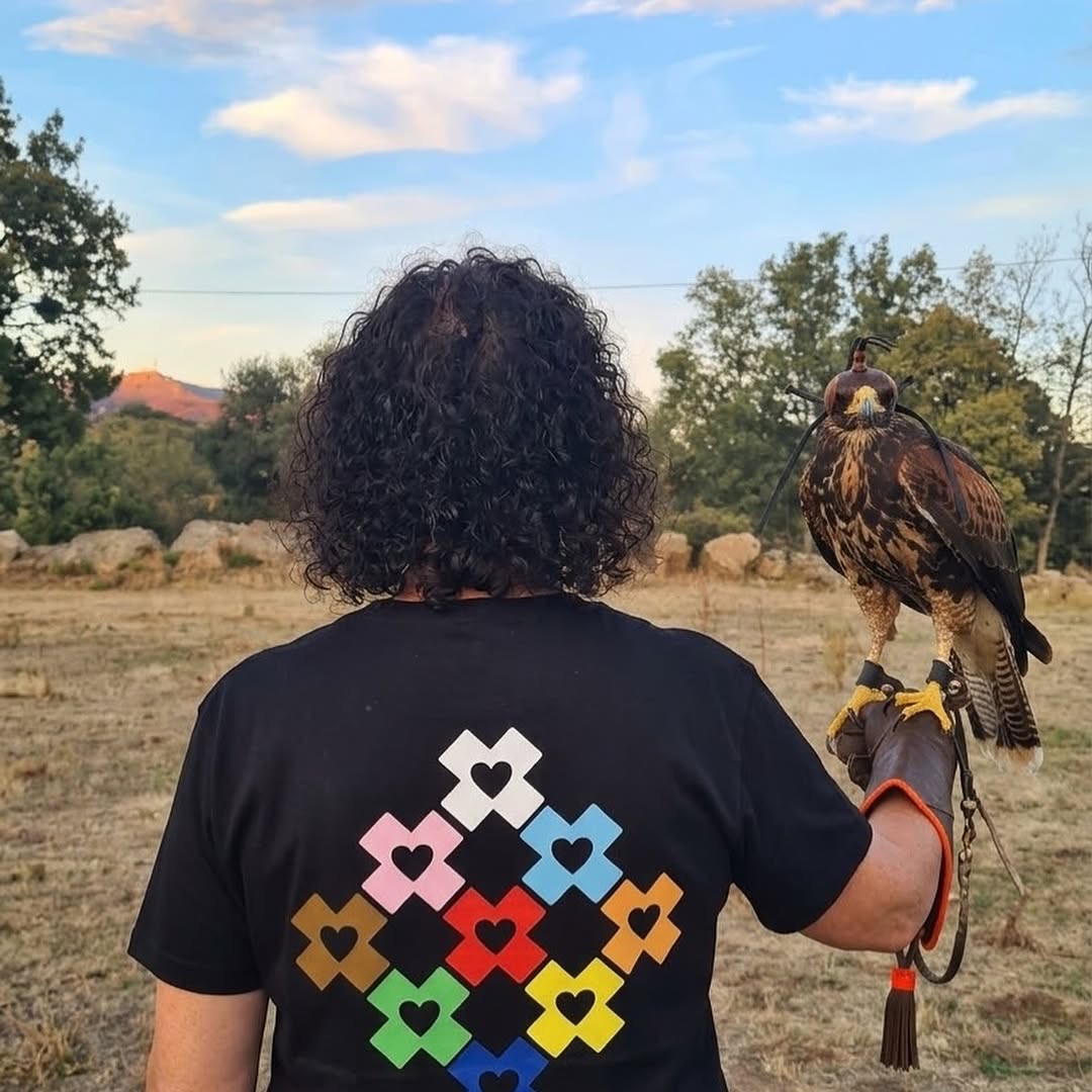 Camiseta negra de Prima’s con las X de colores del orgullo