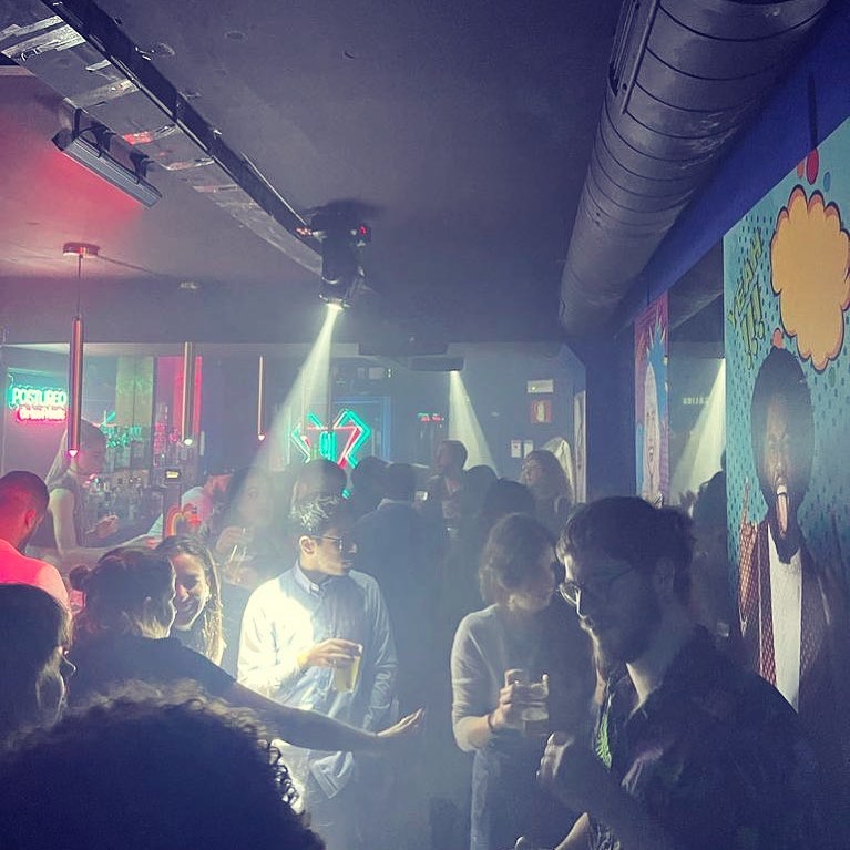 Pista con humo, focos y el neón de Postureo al fondo